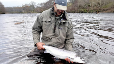 Man holding a Scottish Spring Salmon also know as a Springer